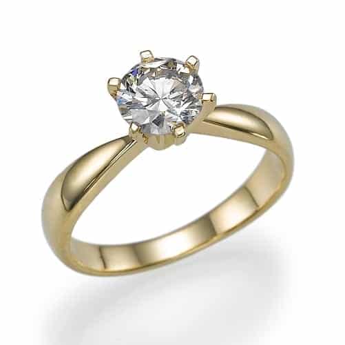 A solitary, brilliant-cut diamond sits atop a classic yellow gold band, symbolizing timeless elegance.