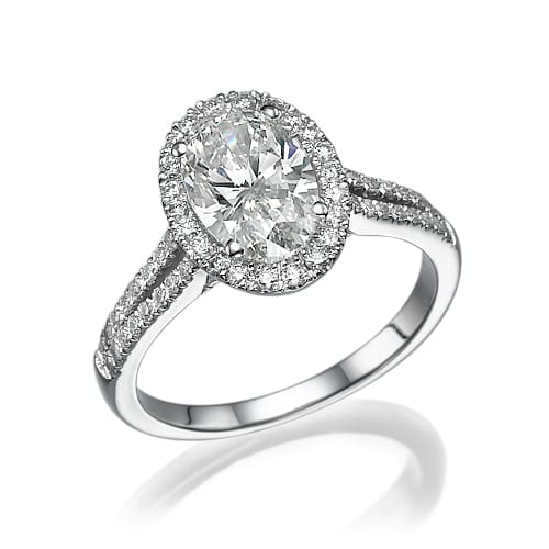 A sparkling oval-cut diamond ring with a halo setting and a pavé diamond band, shining brilliantly against a white background.