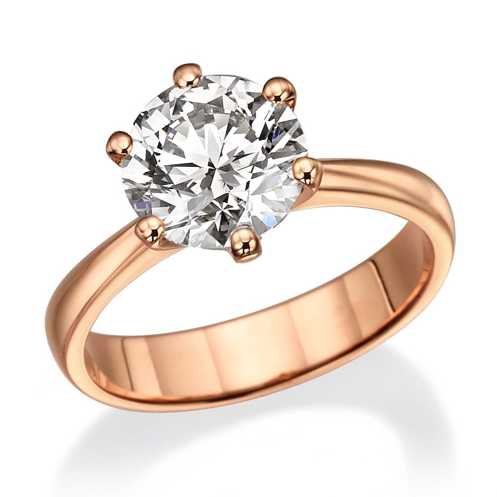 טבעת זהב ורדרד הכוללת יהלום מרכזי גדול בחיתוך מבריק, ולצידה יהלומים קטנים יותר על רצועה חלקה.