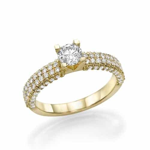 טבעת אירוסין יהלום סוליטר עם יהלומים משובצים בפאב לאורך הרצועה, עשויה זהב צהוב.
