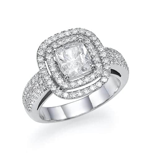 An elegant silver ring featuring a radiant-cut center diamond surrounded by a halo of smaller diamonds, with a pave-set diamond band, showcasing a luxurious and sophisticated design.
