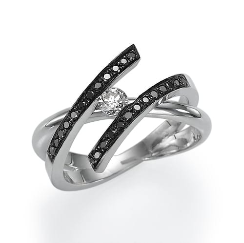 Silver ring with a central diamond and black accent stones in a swirling band design.