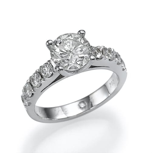 An elegant silver engagement ring featuring a large central diamond flanked by smaller diamonds set into the band.