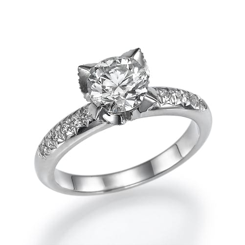 A sparkling solitaire diamond engagement ring with a round brilliant cut center stone set on a silver or white gold band adorned with smaller accent diamonds.