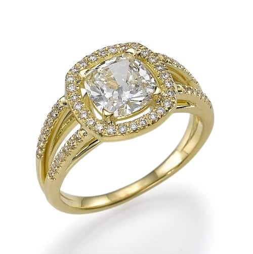 טבעת מוזהבת מעוטרת ביהלום מרכזי גדול בשיבוץ מרובע, מוקפת במספר יהלומים קטנים יותר החוטפים את הרצועה.