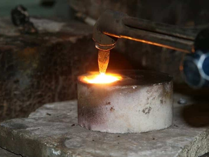 Pouring molten metal into a mold at a foundry.