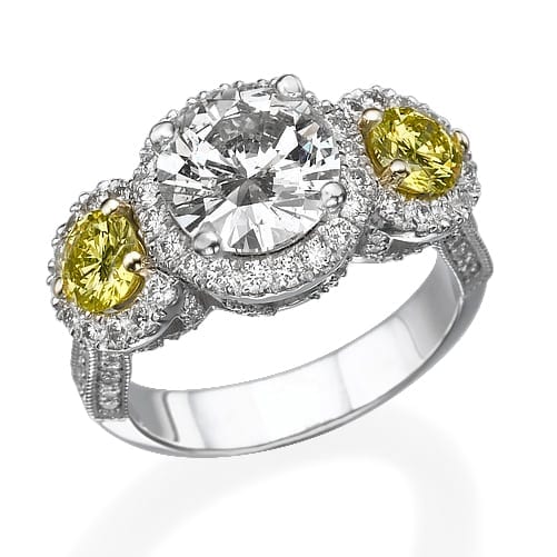 טבעת יהלומים דגם איזבלה אלגנטית הכוללת יהלום מרכזי גדול בחיתוך עגול, ולצידו שתי אבני חן צהובות קטנות יותר, כולן מוקפות בהילה של יהלומים מיניאטוריים.