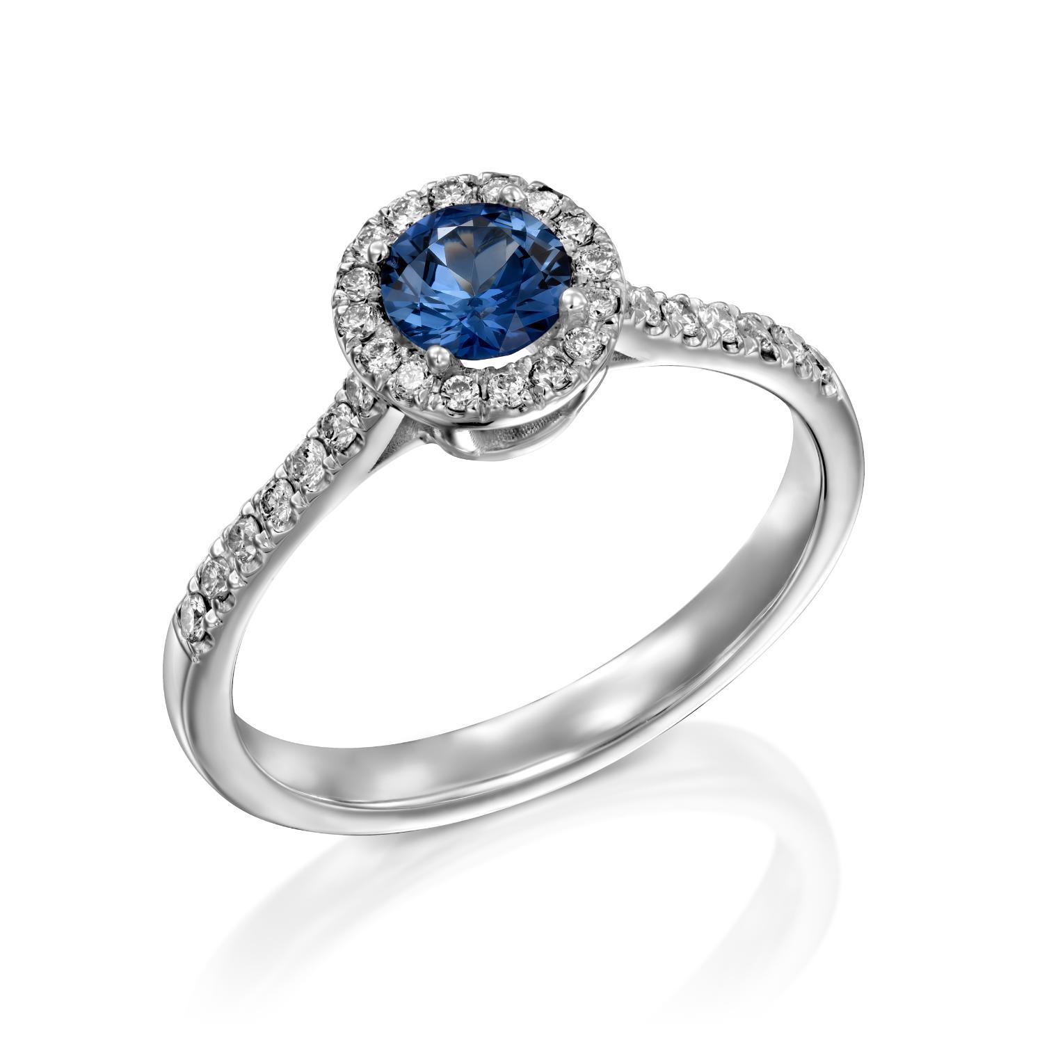 טבעת כסף אלגנטית הכוללת אבן חן כחולה זוהרת מוקפת בהילה של יהלומים נוצצים, משובצת על רקע לבן. זה טבעת ספיר ויהלומים דגם נטלי.