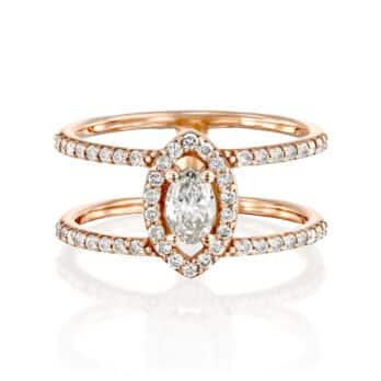 טבעת אירוסין אלגנטית דגם אדריאן בשילוב רצועת נישואין תואמת, מציגה יהלום מרכזי בצורת אגס מוקף בהילה של יהלומים עגולים קטנים יותר.