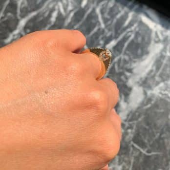אגרוף קפוץ מציג טבעת אירוסין דגם שונית ב-35% הנחה בעיצוב בצורת לב ואבני חן קטנות.