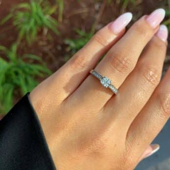 יד עם סט ציפורניים מטופח טרי מציגה טבעת אירוסין נוצצת טבעת יהלומים ירין ב-35% הנחה.