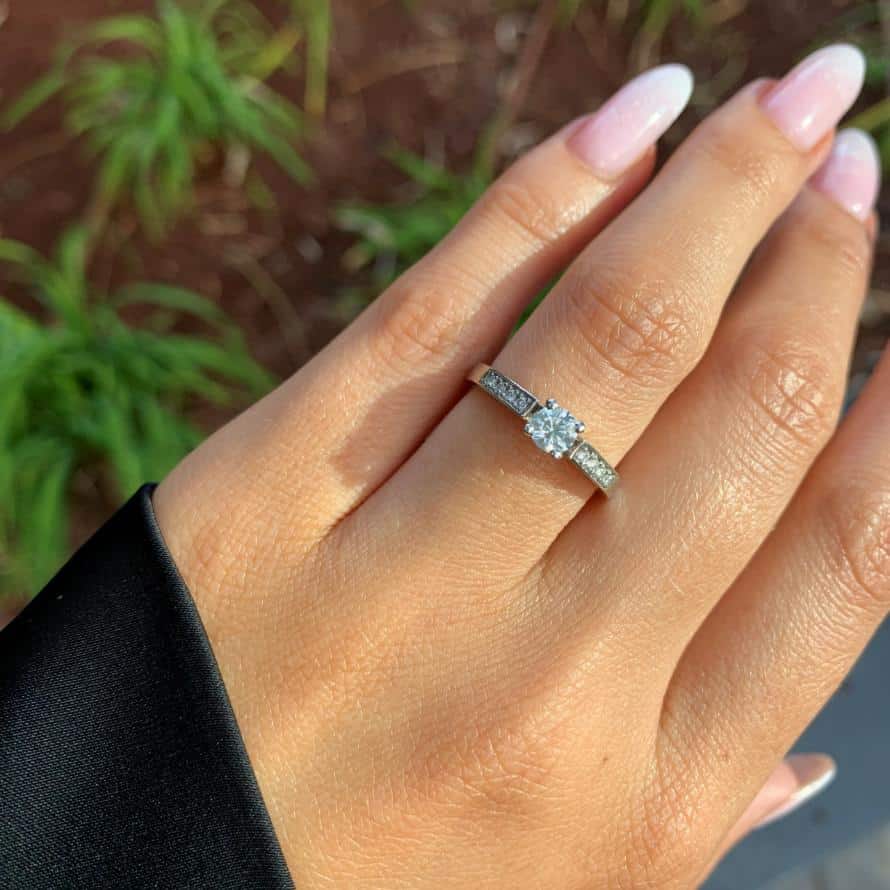 יד עם סט ציפורניים מטופח טרי מציגה טבעת אירוסין נוצצת טבעת יהלומים ירין ב-35% הנחה.
