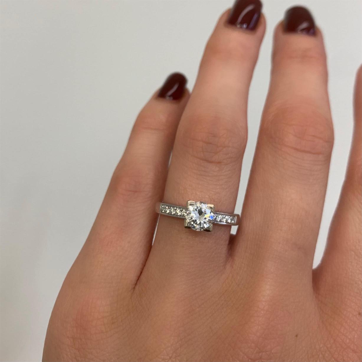 יד אלגנטית המתהדרת בטבעת אירוסין נוצצת, דגם טבעת אירוסין Jenika עם רצועת כסף מעוטרת באבנים קטנות, עכשיו ב-47% הנחה.
